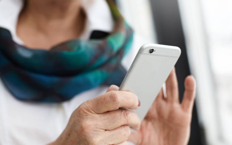 中年妇女使用手机表示多位脚本患者通过跟踪社交渠道保持连接